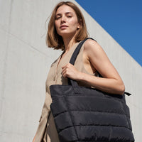 VELÁ Puffer Tote in Black, worn on the shoulder