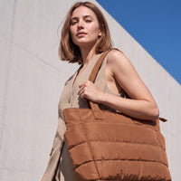 VELÁ Puffer Tote in Brown, worn on the shoulder